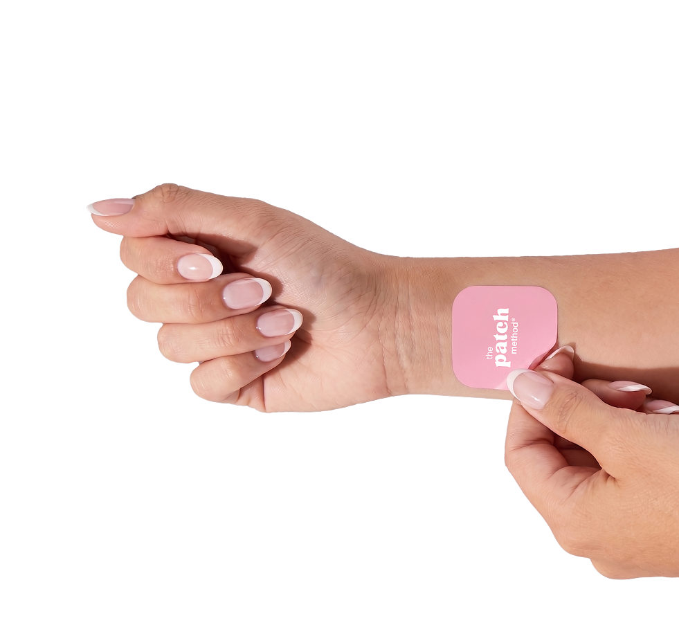 Close-up of a forearm and wrist with a pink Patch Method patch applied, isolated on a white background
