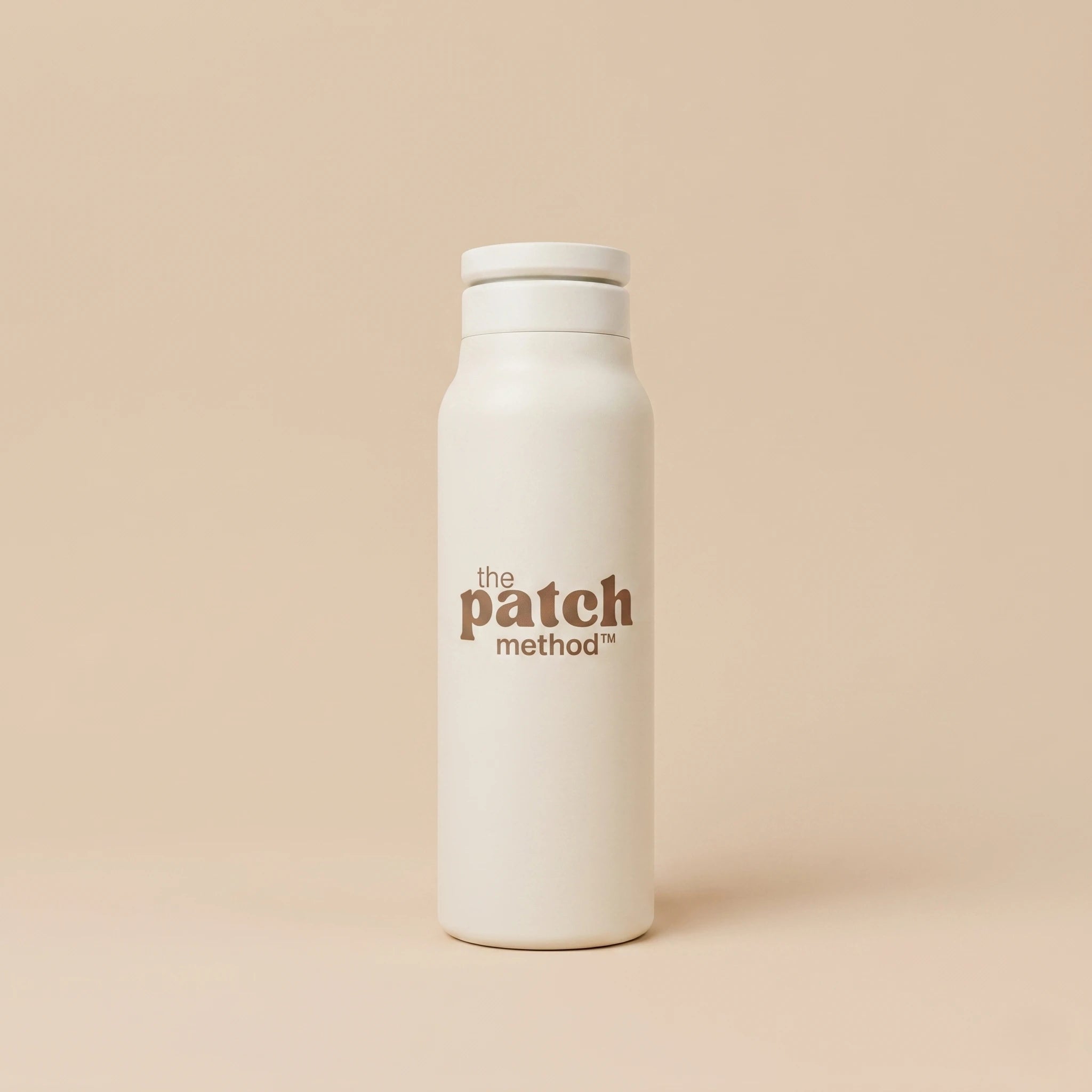 White water bottle with 'the patch method' logo on a beige background